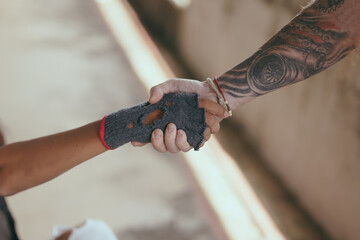 Close-up handshake homeless man on walkway street in the city., homeless poor people and depression...