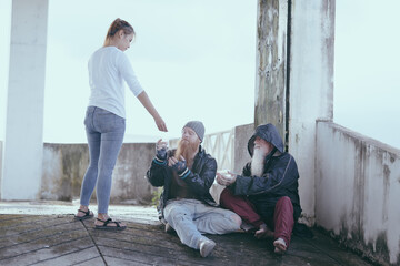  female giving money to poor or homeless people poverty beggar in the city sitting on the streets with a sign for help., homeless poor people and depression concepts.