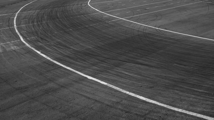 Background with tire marks on road track, Car track asphalt pavement background at the circuit, Abstract asphalt road background with crossing of tires tracks, Black tyre mark on asphalt road. © Darunrat