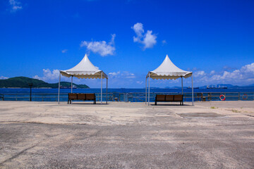 Benches with tent at the seashore under the blue sky