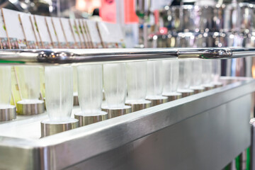 row glass bottle arrange on automatic bottle washer and sanitizing machine in beverage industrial