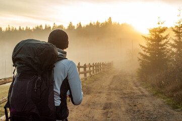 a man with a large tourist backpack looks at the sunrise landscape tourism travel hiking...