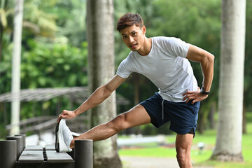 Handsome sportsman warming up before sports training outdoors. Healthy lifestyle, workout and wellness concept