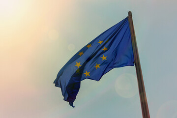 Dramatic view on a dark silhouette of flag of the European Union on a background of sunlight