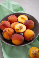 Close up of fresh peach fruit sliced and whole in bowl summer food