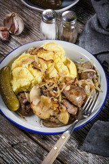 Fried liver with onion and apple, served with boiled potatoes and pickled cucumber.