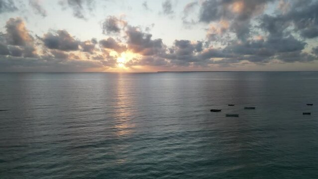 Boats anchored near Uroa beach coast in Zanzibar Island, Tanzania Africa during sunset, Aerial dolly right shot