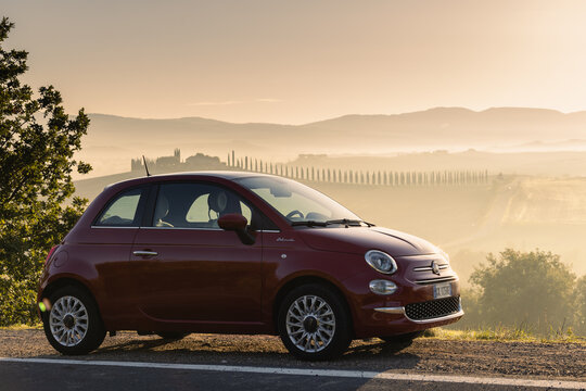Red Fiat 500 in Toscana, Italy during sunrise. 