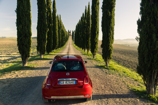 Red Fiat 500 in Toscana, Italy during sunrise. 
