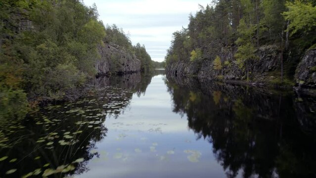 Fly close over water of oblong lake in forest, autumn day in Sweden prt 1