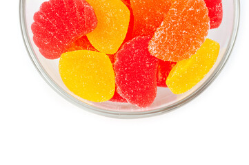 Jelly sweets citrus mix unglazed lying in a round glass bowl.