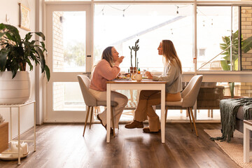Two women eating meal together at home
