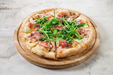 Fresh pizza with meat and ham on the concrete background