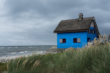 blue house at the beach in a storm