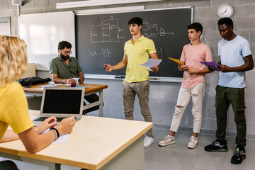 Multiethnic group of three young male students teaching personal project about electronics and technology to classmates in classroom at high school - Teamwork and education concept - obrazy, fototapety, plakaty