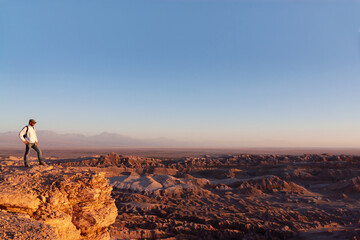 Man at sunset on red rock in the Atacama desert