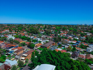 Obraz premium Panoramic Aerial Drone view of Suburban Sydney housing, roof tops, the streets and the parks