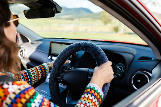 Navigation GPS System in electric vehicle car with woman's hand on wheel