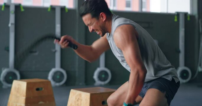 Exercise, rope workout and a man in gym training and building muscle strength. Balance, motivation and fitness, high energy performance bodybuilder with power, wellness and strong healthy lifestyle.