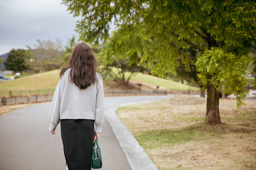 公園を一人で歩く女性の後ろ姿  woman