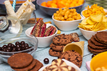 Salty and sweet snacks. Table of salty and sweet snacks. Large group of unhealthy food