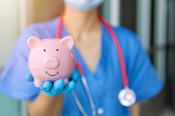 medical staff hand showing piggy bank smile for saving money for future healthcare health insurance...