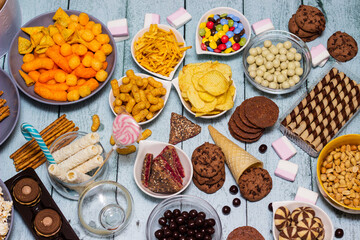 Salty and sweet snacks. Table of salty and sweet snacks. Large group of unhealthy food