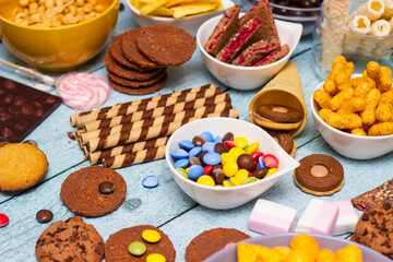 Salty and sweet snacks. Table of salty and sweet snacks. Large group of unhealthy food