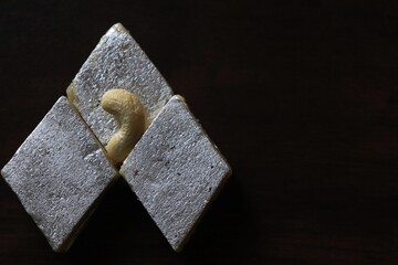 Close-up of Indian sweet Kaju Katli/Cashew Barfi against black background