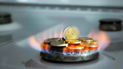 Concept of gas crisis. 2 Euro coins is burning on a kitchen stove burner and fall when the gas end. High prices of natural resources. Fire flame. Utility debt. Energy war. Saving home budget. Finance