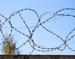 Barbed wire against the blue sky.