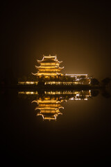 Illuminated Vietnamese temple on the water at night