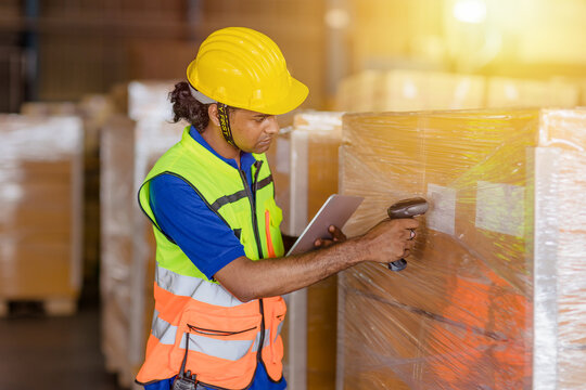 indian worker in logistics industry working inventory management system using barcode reader and tablet computer