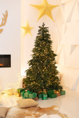 Christmas tree with lights glowing garlands and gifts. Festive interior design living room with a Christmas tree and decorations. Xmas at home. New year winter home decor. 