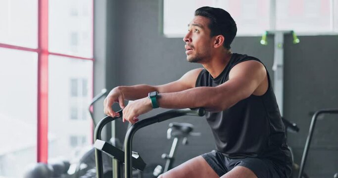 Fitness, bicycle and man tired of cycling for cardio, exercise and training at gym. Wellness, workout and strong Asian man breathing and sweating thinking of motivation and goal on a bike machine