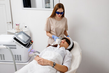 .Professional cosmetologist is making cavitation rejuvenation skin treatment in clinic. Radio wave...