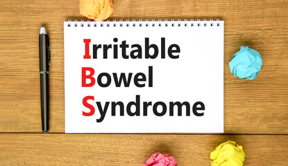 IBS irritable bowel syndrome symbol. Concept words IBS irritable bowel syndrome on white note on a beautiful wooden background. Medical and IBS irritable bowel syndrome concept. Copy space.
