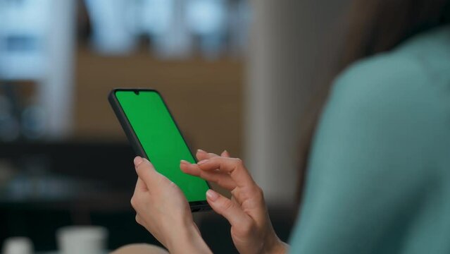 User scrolling chroma key smartphone at office closeup. Woman holding device