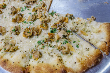 Closeup of clam pizza at a pizza shop. This is the local specialty in Connecticut, USA and is made...
