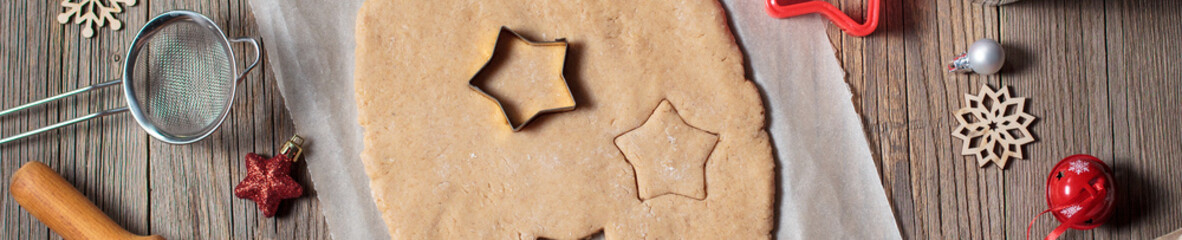 banner of Baking homemade Christmas gingerbread cookies. top view of holiday background with dough spices and fir tree.