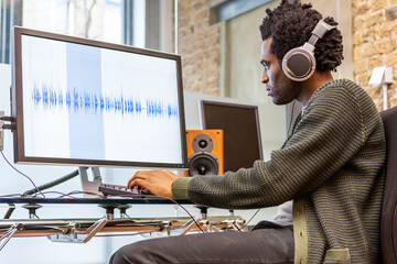 The Media Agency: Sound Engineer. A music producer at work in his recording studio - generic waveform on screen. From a series of related images.
