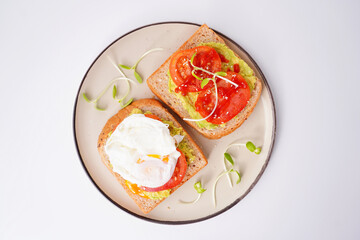 Breakfast, avocado on wholemeal bread and boiled egg on white background