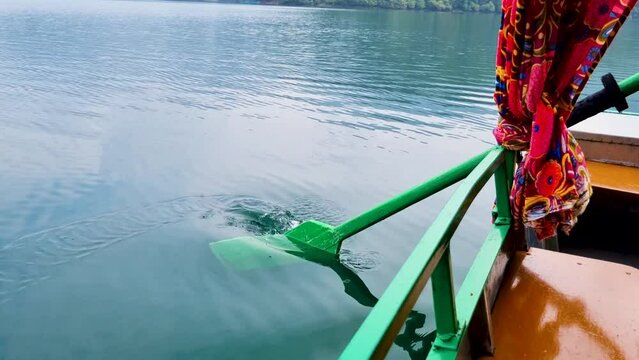 close up slow motion shot with green oars dipping into blue green water on the shikara type row boats in nainital naukuchiatal bhimtal showing detail shot for this tourist attraction