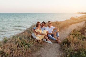 Happy middle-aged family with an adult son by the sea. Close-up photo.