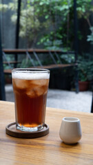 a glass of lemon tea and mini cup of sugar on the table outdoor