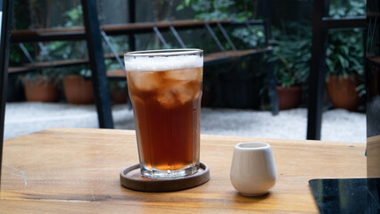 a glass of lemon tea and mini cup of sugar on the table outdoor