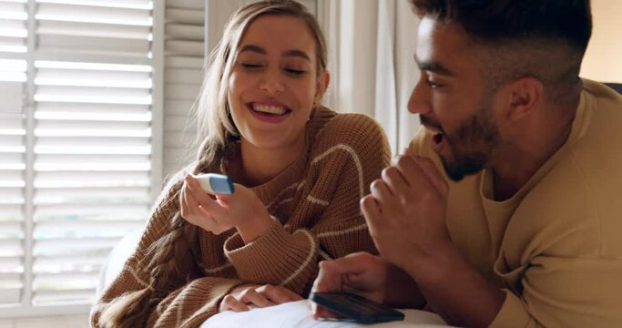 Surprise, couple and pregnancy test announcement with excited boyfriend hugging girlfriend. Husband browsing on phone being shocked by wife pregnancy results in bedroom. Young people expecting baby
