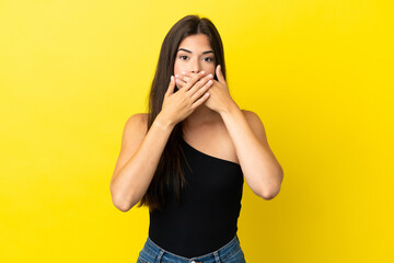 Young Brazilian woman isolated on yellow background covering mouth with hands