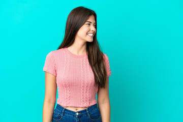 Young Brazilian woman isolated on blue background looking side
