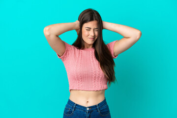 Young Brazilian woman isolated on blue background frustrated and covering ears